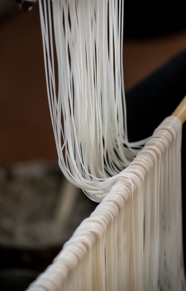 16、2022年9月22日,广西梧州市苍梧县京南米粉厂,工人在米粉出丝生产线上忙碌。(何华文)