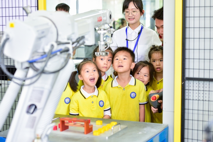 15、2020年11月18日，在广西梧州商贸学校幼儿园的小朋友饶有兴趣参观工业智能制造体验，产生好奇，感受科技的魅力。