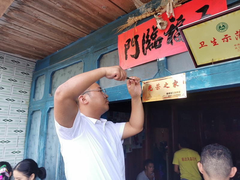 2.工作人员为新兵潘元家属装订“光荣之家”牌匾