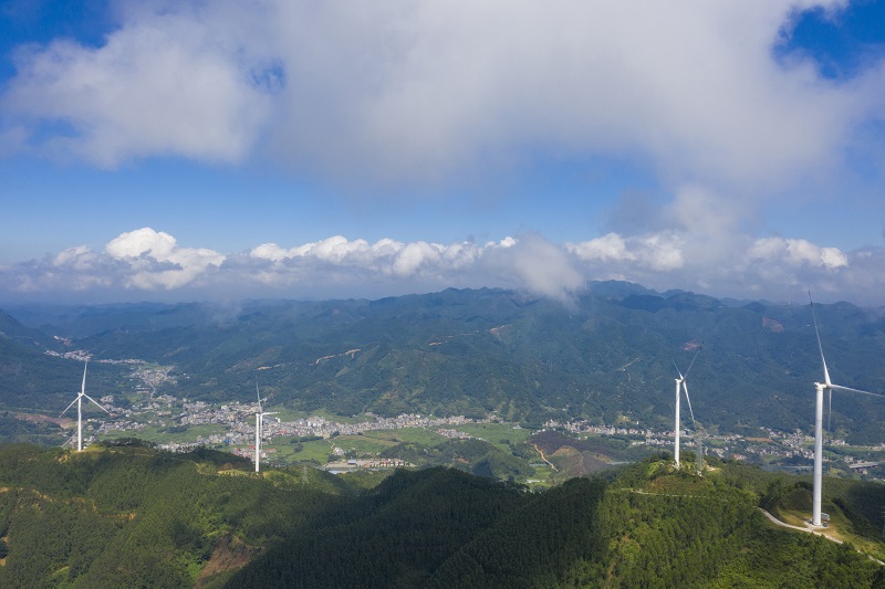 3、2021年9月25日，在广西梧州岑溪市大隆镇东南一带山脊上的中广核风电场现场，青山叠翠，15台风力发电机组与云雾、乡村相映成景，构成了一道美丽的绿色画卷。（何华文）