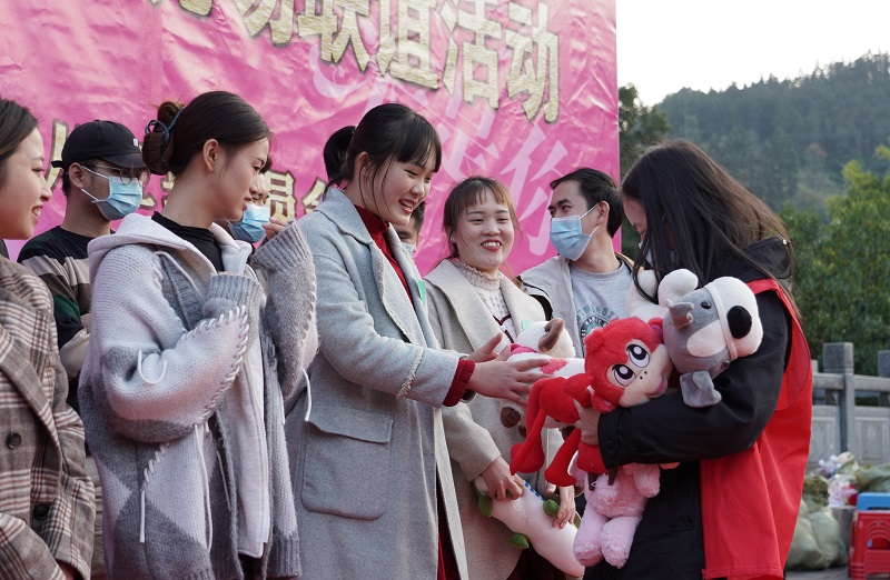 12月17日，2021年从江县“爱在工会，缘来是你”单身青年职工联谊活动在从江县鼓楼广场举行，工作人员正为男女嘉宾发放奖励品。