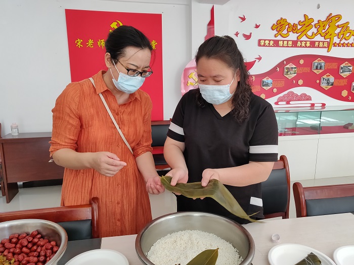 图为5月28日，县直部门（单位）在职党员们在福海镇永安路社区开展“逢8”志愿服务活动，与社区党员干部居民比拼包粽子技艺，迎接端午节的到来。2