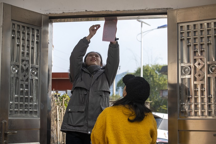 17、2023年1月20日，广西梧州市万秀区夏郢镇古藤村的村民沿袭传统的过年风俗，在自家门头贴春联，喜迎新年。（何华文）