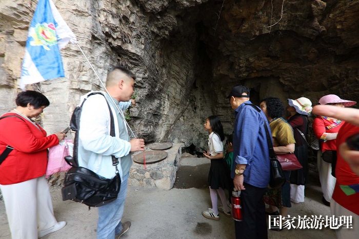 图2：万州国际太白旅行社组团游下庄参观当年下庄人修筑天路用过的锅灶。2023年5月20日，摄于重庆巫山下庄天路。唐金生摄