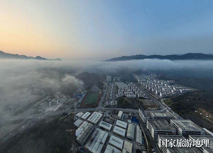 6、2023年11月23日，俯瞰广西河池市凤山县城一幢幢排列整齐的老乡家园、喀斯特青山在云雾缭绕下，宛如一幅生态画卷，美不胜收。（何华文）