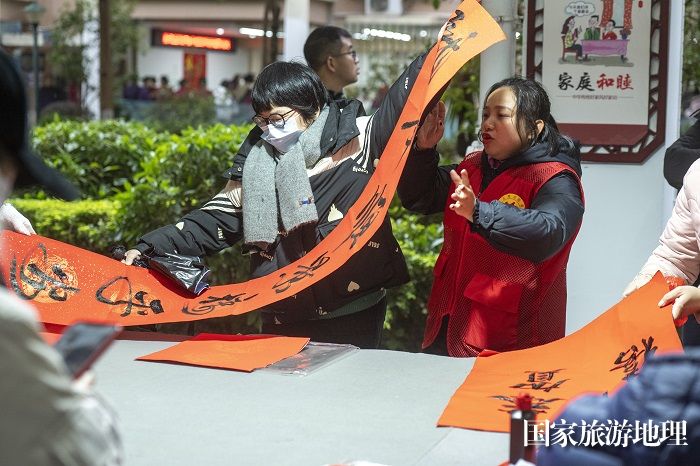 6、2024年1月27日，在广西梧州市万秀区蓝天港湾小区迎春文化活动现场，志愿者为居民写春联。（何华文）