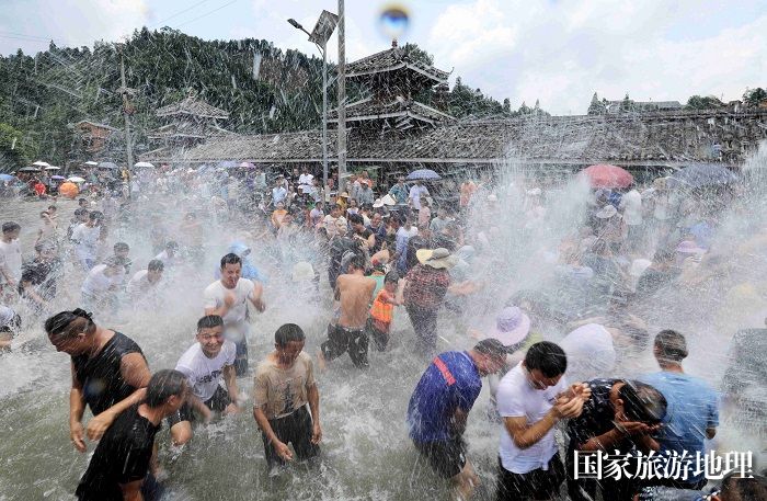 图1：7月11日，在广西柳州市融安县长安镇安宁村大袍苗寨，游客和村民在“闹鱼节”上戏水。（谭凯兴 摄）